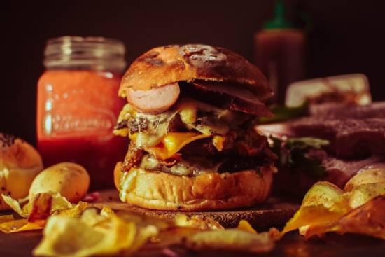 Large burger surrounded by potato chips A massive burger with potato chips illustrates the unhealthy choices and lack of self-control.
