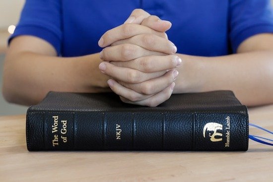 A Christian praying for guidance before planning a small group Bible study