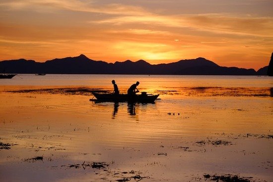 Fishermen out on a lake at sunset, similar to how some of Jesus' disciples were fishermen