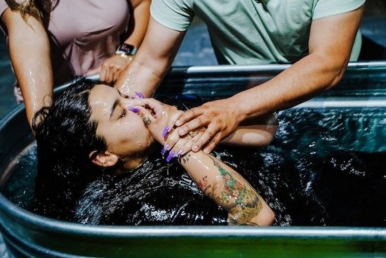 A woman being baptized by immersion to become a member of the Seventh-day Adventist Church