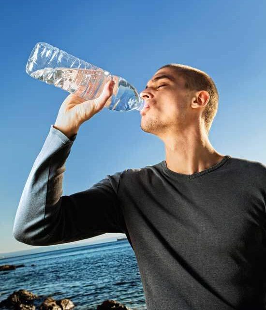A man drinking a bottle of water, which is one of the health principles of the Seventh-day Adventist Church