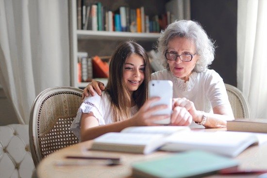 A child showing her grandmother how to visit the AskAnAdventistFriend website using the QR code on the Ask a Friend cards