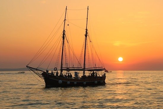 A sailboat with the sun setting behind