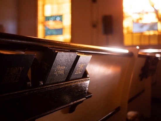 Hymnals stored in the back of a church pew