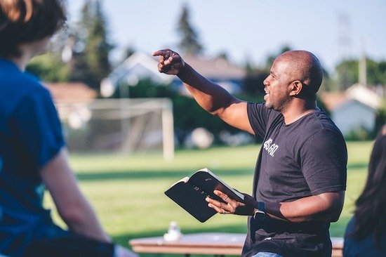 A man preaching from a Bible in his hand