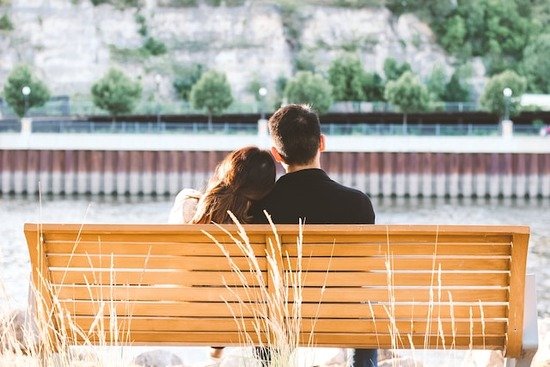 Two young people sitting on a bench together