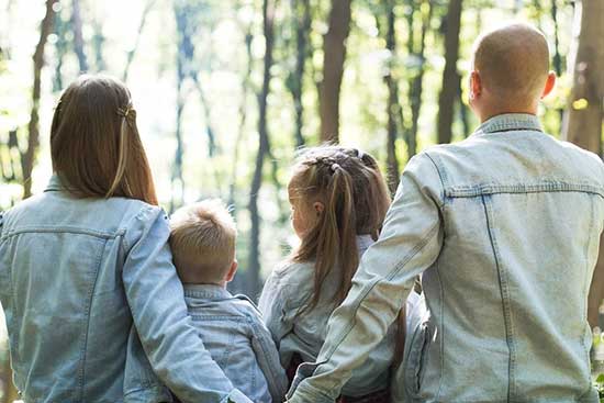 Parents with two children sitting in nature together