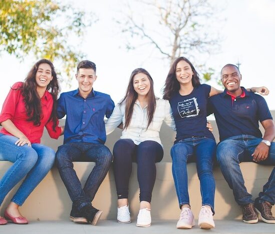 Adventist high school students sitting on a bench with arms around each other