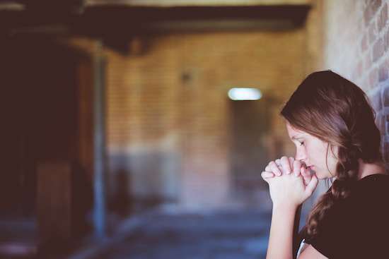 A woman praying and reflecting on her own actions