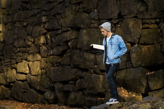 A young man reading his Bible outside