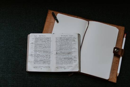 An old Greek Bible open on top of a notebook 