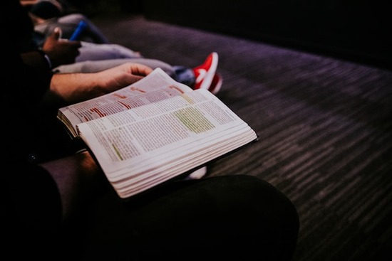 Two people sitting together and reading the story of Philip in the Bible