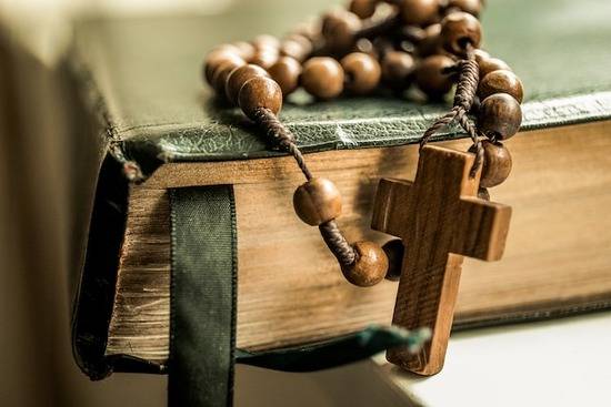 A rosary on top of a Catholic Bible