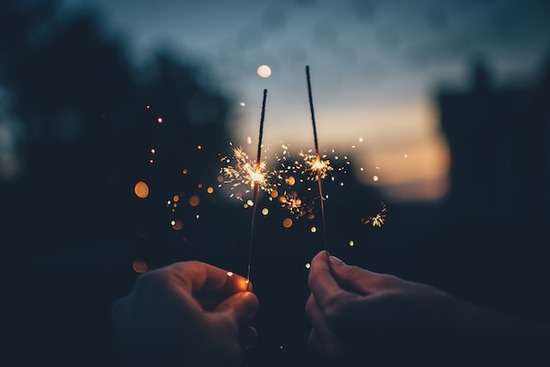 Hands holding sparklers for a holiday celebration