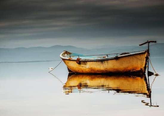 A fishing boat on a lake, representing the kind of fishing boat the disciples might have used in first century Palestine