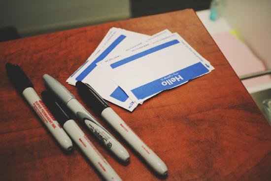 White name tags and black sharpies on a table