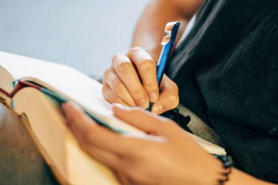 A woman taking notes as she studies her Bible