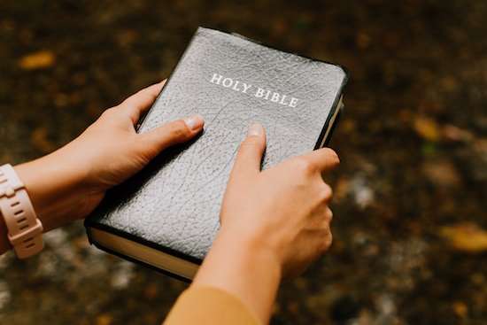 A woman holding onto a Bible