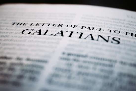 A Bible open with the text 'The Letter of Paul to the Galatians'