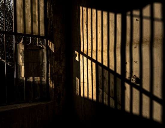 Shadows of prison bars reflecting off concrete walls