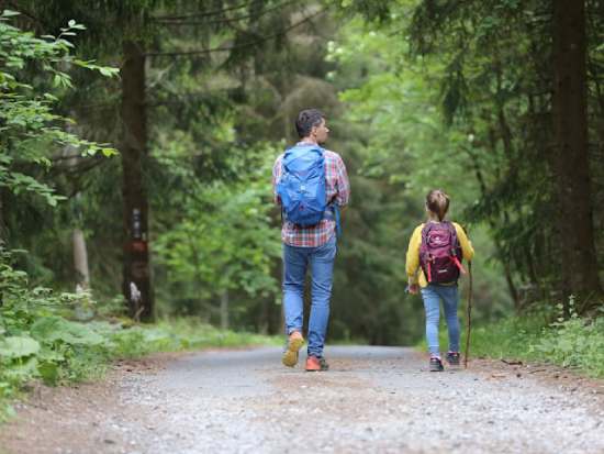 A father and daughter hiking together and enjoying a full and healthy life