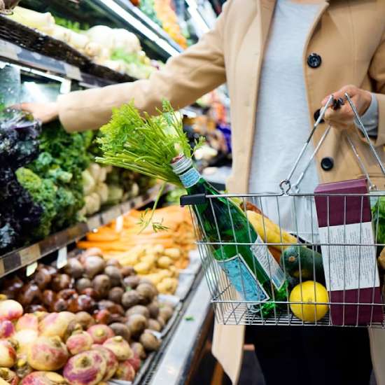 A woman carrying a basket as she shops for groceries