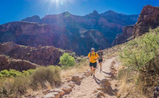 Two men running on a trail in the desert and demonstrating the trait of perseverance