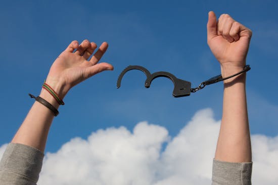 a man with open handcuffs Hands breaking free from handcuffs