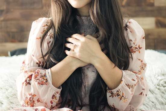 A women's living soul A woman, a living soul, with her hands clasped over her heart