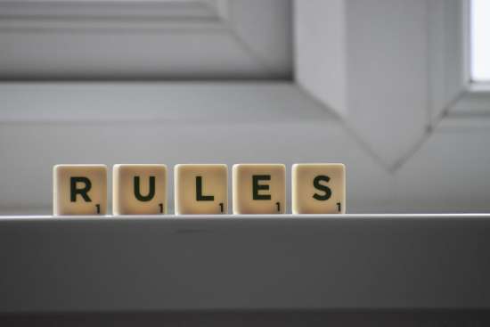 Scrabble tiles spelling out the word 'rules.'