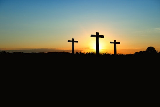 Three crosses at sunset Three crosses stand near each other underneath a sunset sky.