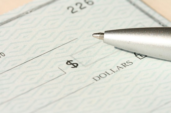 Pen Sitting on Top of a Cheque A visual of a blank check with a pen next to it indicates that on the surface, the Parable of the Talents talks about handling money.