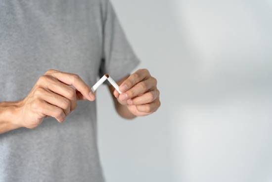Man breaking cigarette in half A man breaks a cigarette in half, demonstrating how Jesus can help us overcome destructive habits.