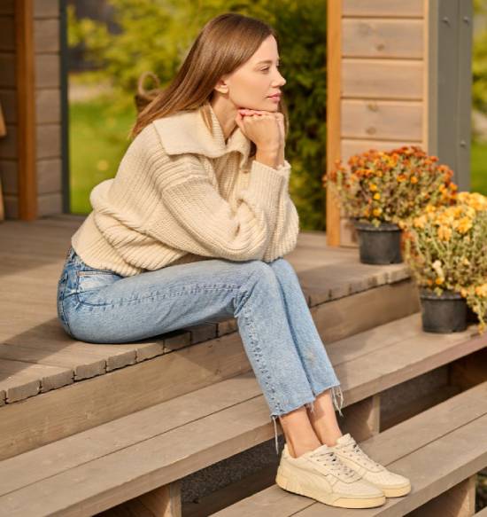 Woman sitting on her porch in the country A young woman sits on her porch contemplatively.