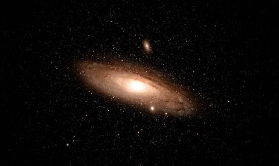 An image of a galaxy and its surrounding stars in space.