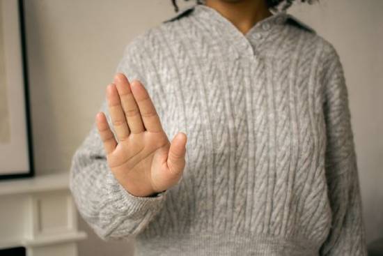 A woman doing stop gesture signifying she's rejecting something A woman holds out her hand to signal stop